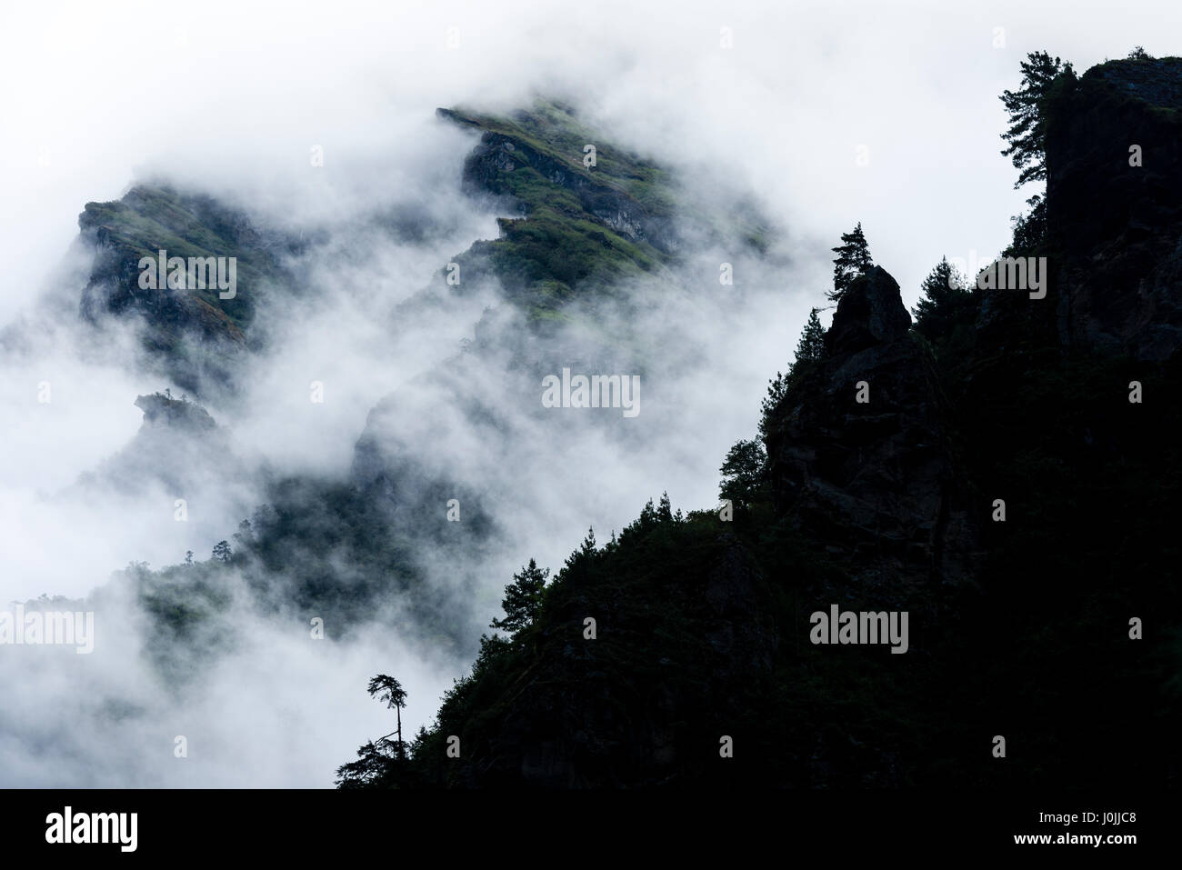 Copertura nuvolosa sul lato della montagna Thamserku, Nepal. Foto © robertvansluis.com Foto Stock