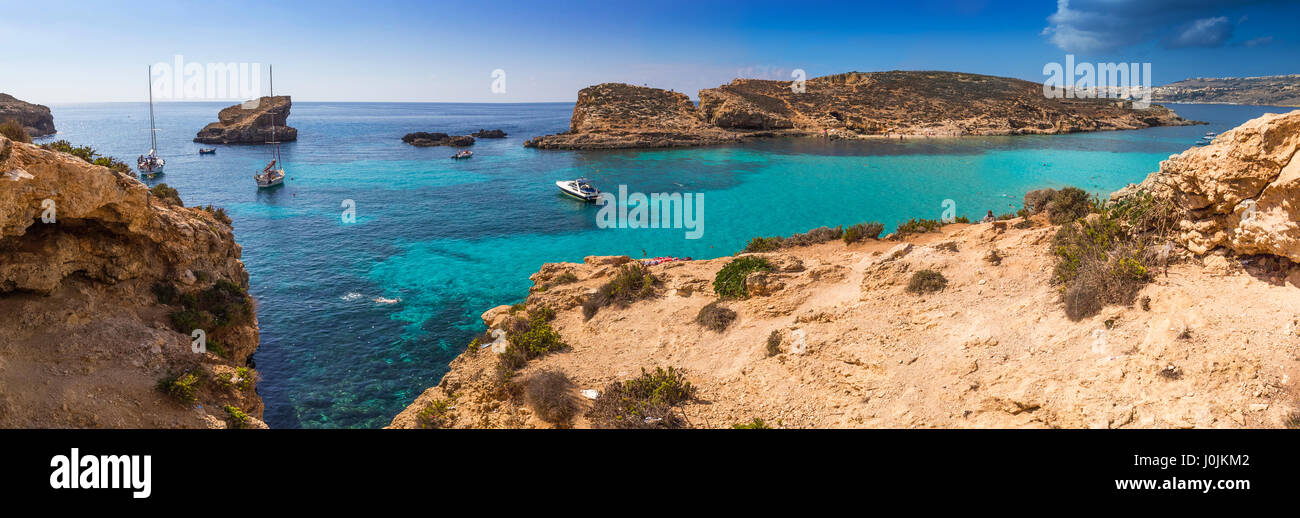 A Comino e Malta - La splendida laguna blu con il turchese chiaro l'acqua di mare, yachts e snorkeling turisti su una soleggiata giornata estiva con l'isola di Gozo Foto Stock