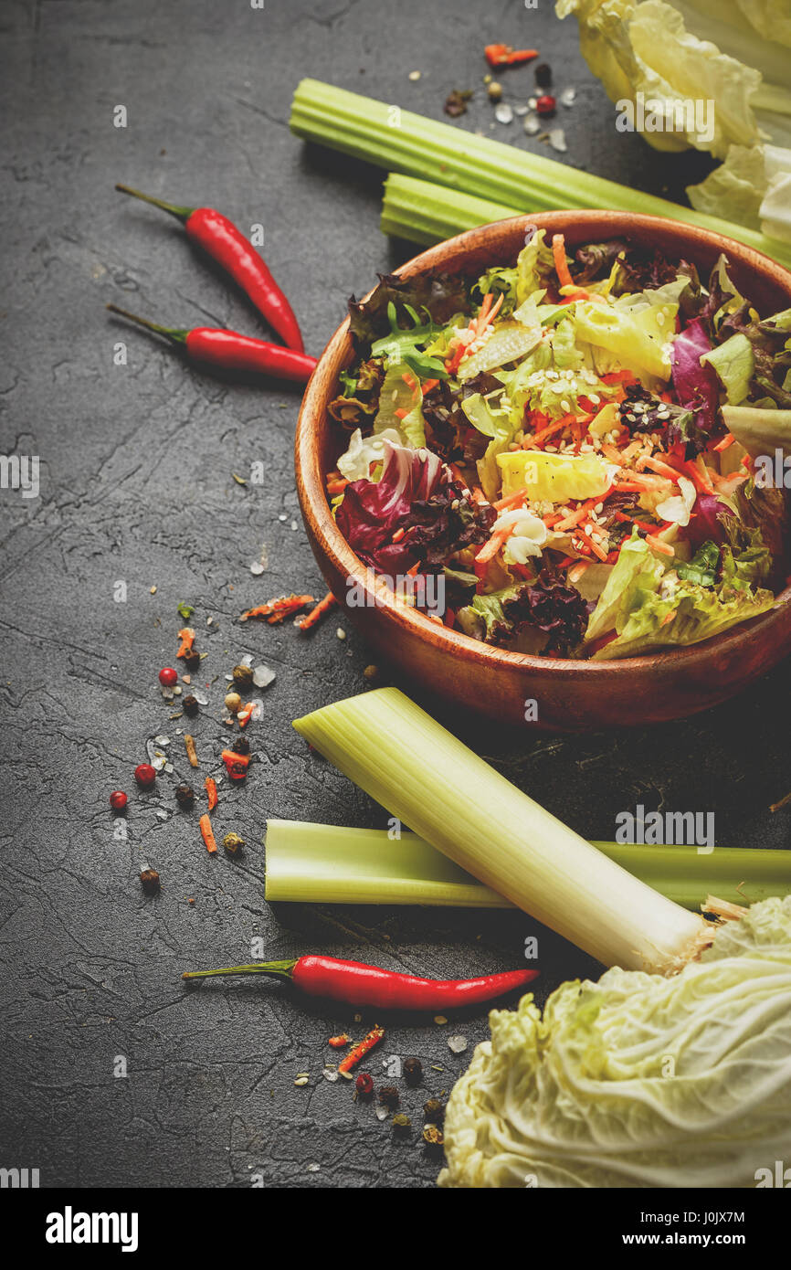 In casa vegetariano con insalata di congelare, lollo rosso, radicchio, romano e iceberg con carote su sfondo nero Foto Stock