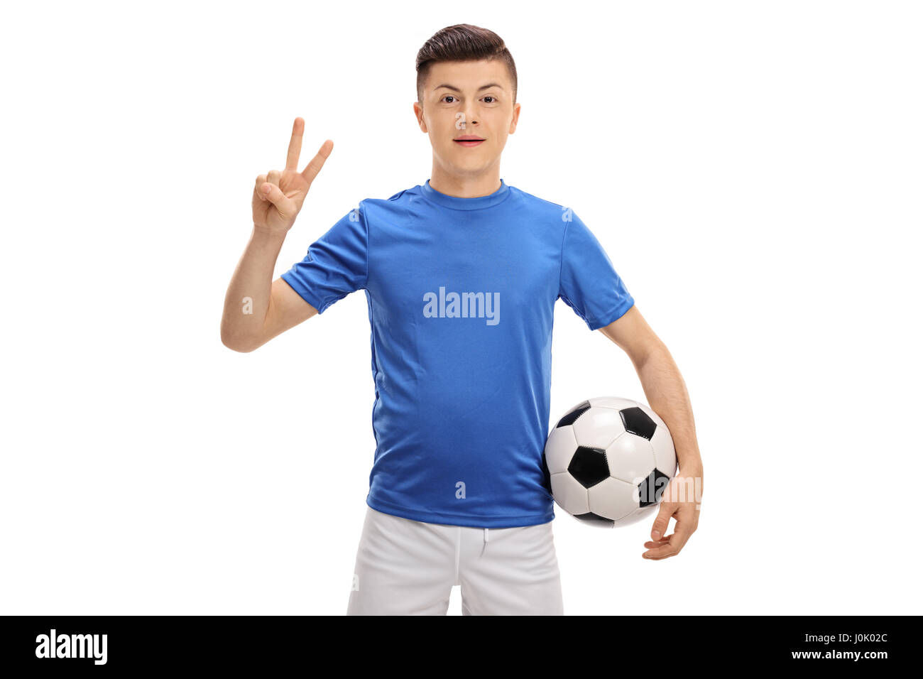 Teenage giocatore di calcio con un pallone da calcio facendo un segno di vittoria isolati su sfondo bianco Foto Stock