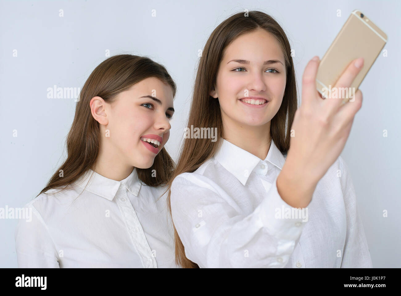 Due belle ragazze facendo selfie studio, tema turismo e divertimento Foto Stock