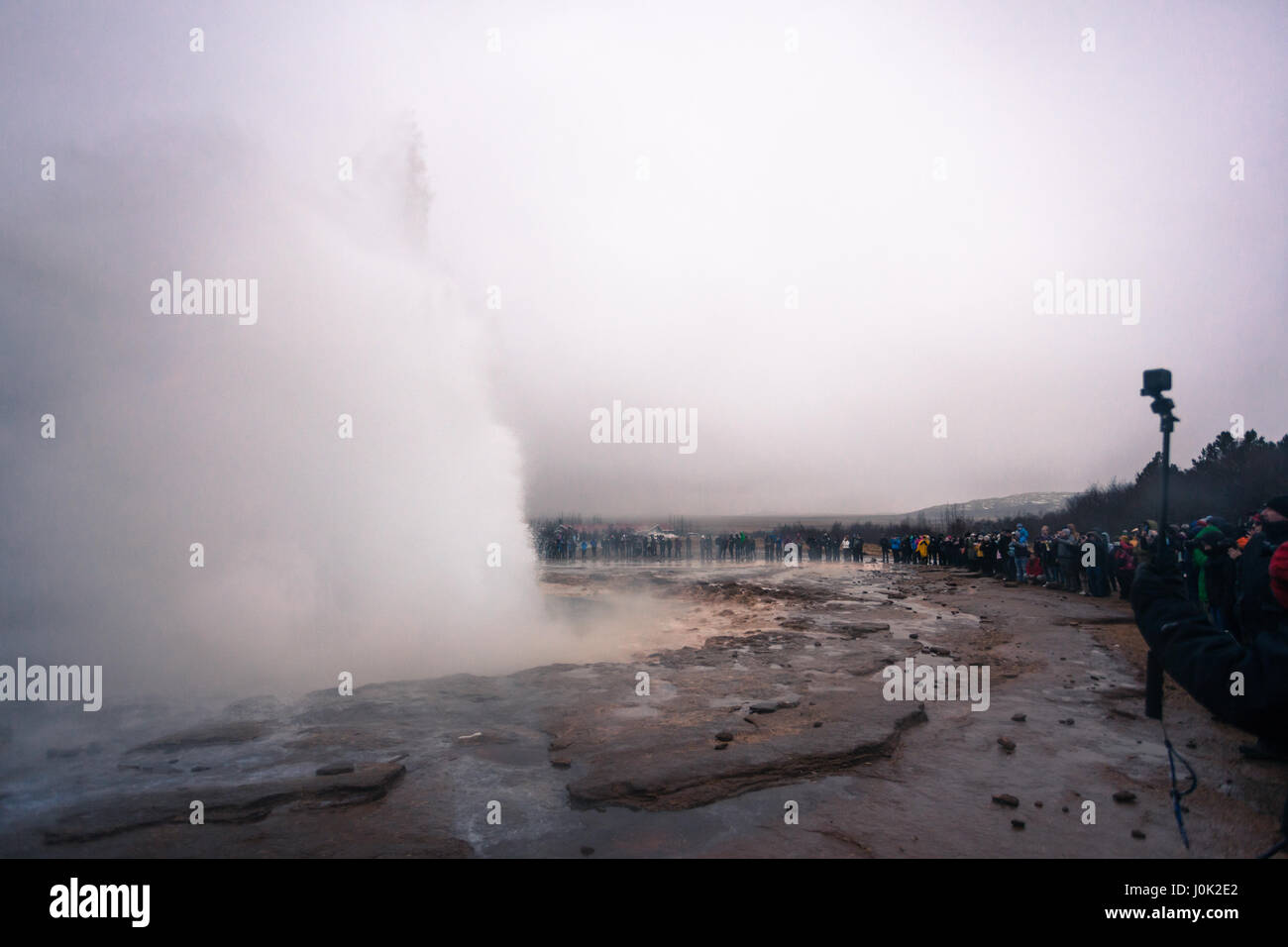 Fotografi e turisti la linea fino a catturare l'eruzione da Strokkur, il geyser Situato nel Golden Circle, Islanda Foto Stock