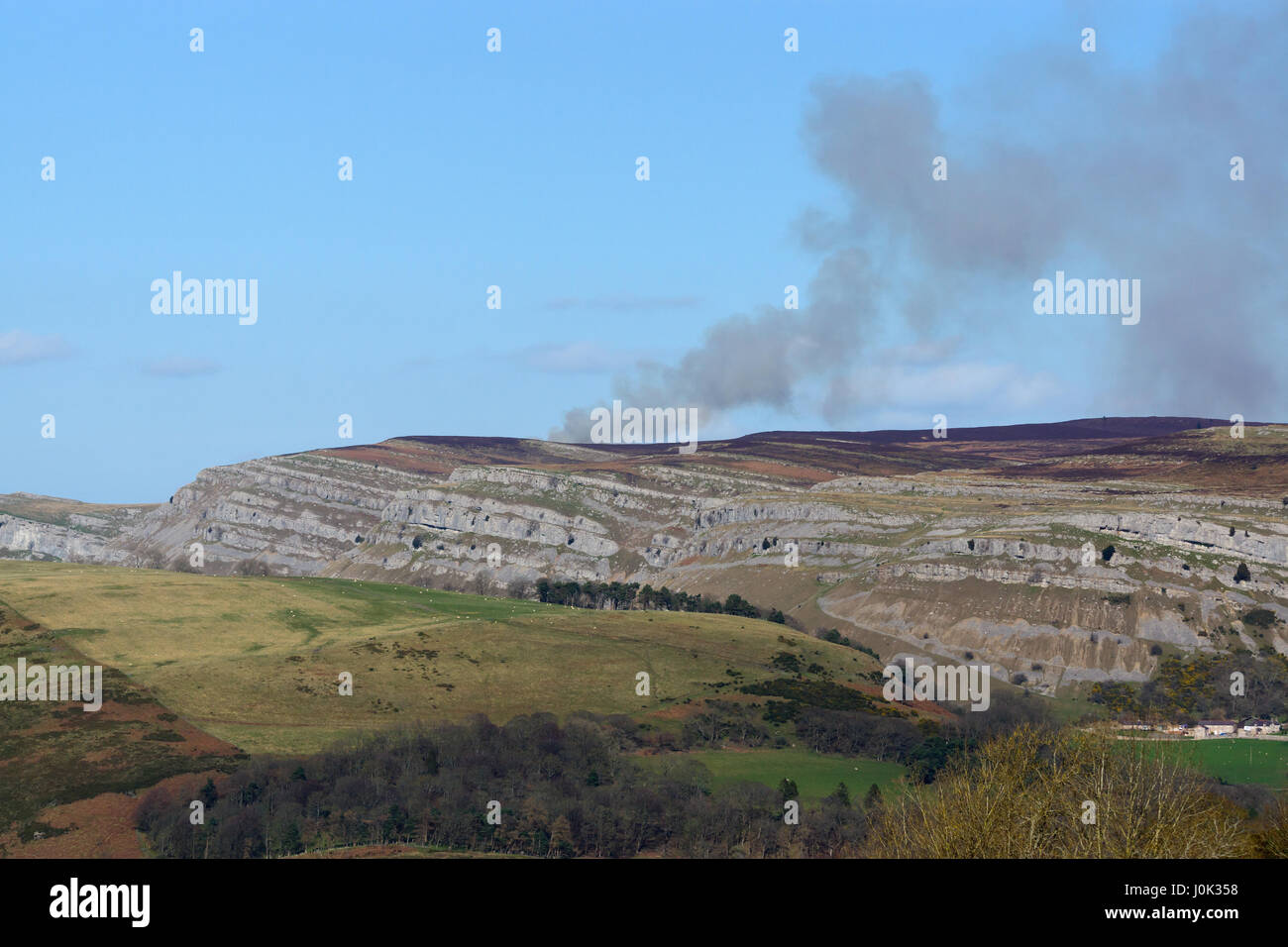 Il fumo proveniente da una lontana heath fuoco sulla Eglwyseg scarpata in prossimità dei mondi fine sopra Panoroma Llangollen in Denbighshire Galles Foto Stock