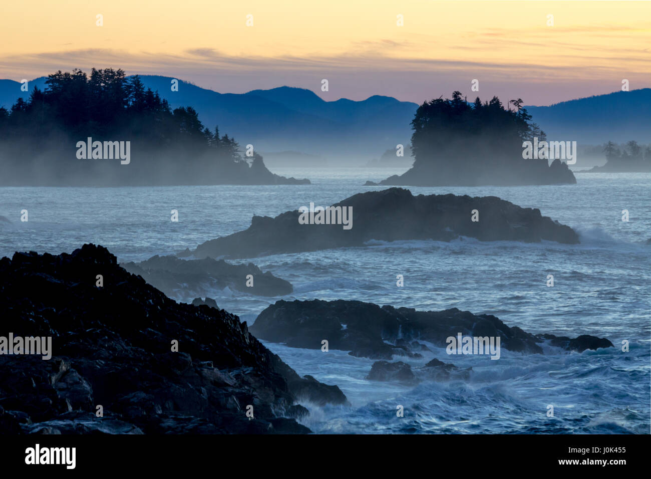 Di ispirazione pre-alba luce sul robusto della costa occidentale dell'isola di Vancouver vicino a ucluelet cercando se attraverso sagome delle rotte delle isole del gruppo Foto Stock