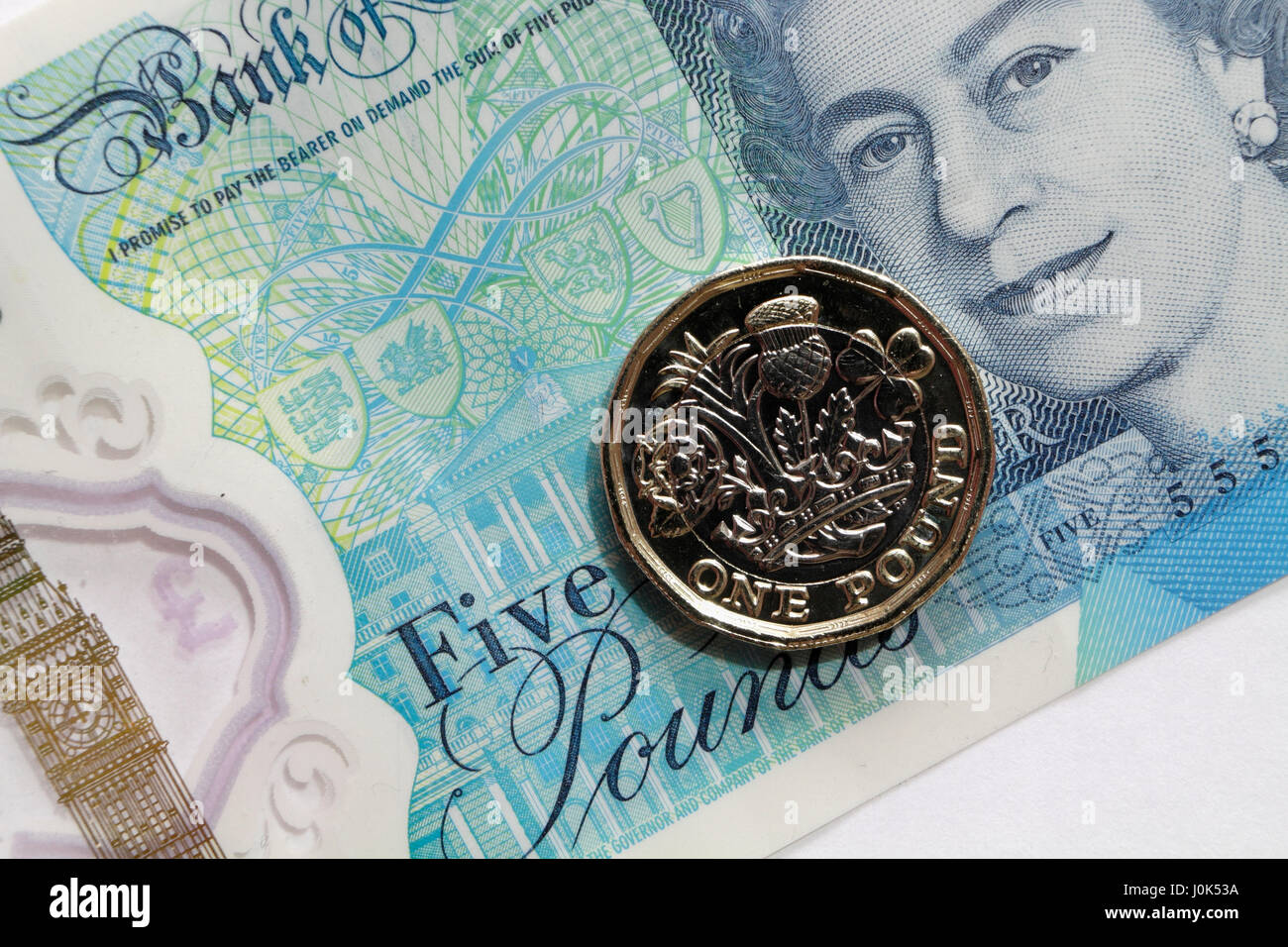 Nuova moneta inglese e nuova nota da cinque sterline, valuta di denaro Foto Stock