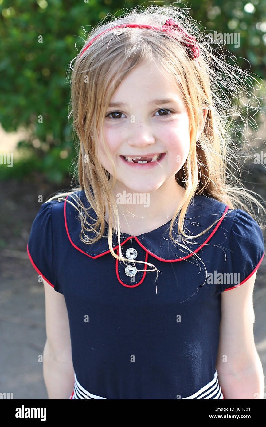 Bambino, ragazza con i capelli lunghi con un materiale gommoso un grande  sorriso e denti mancanti Foto stock - Alamy
