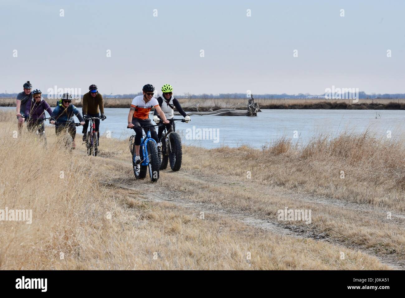 Gruppo di equitazione ecotourists fat tire biciclette attraverso la prairie con la gru di fiducia al di fuori della proprietà Grand Island, Nebraska, Stati Uniti d'America. Foto Stock