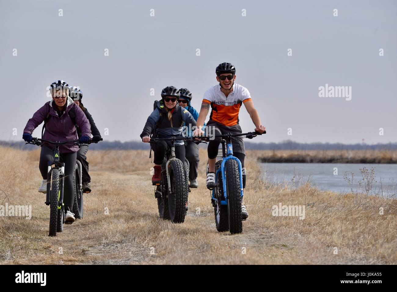 Gruppo di equitazione ecotourists fat tire biciclette attraverso la prairie con la gru di fiducia al di fuori della proprietà Grand Island, Nebraska, Stati Uniti d'America. Foto Stock