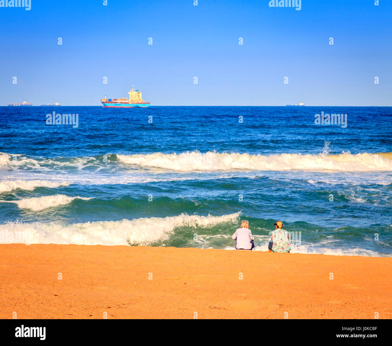 Due donne stanno godendo la sera di sole sulla spiaggia a Durban, Sud Africa Foto Stock