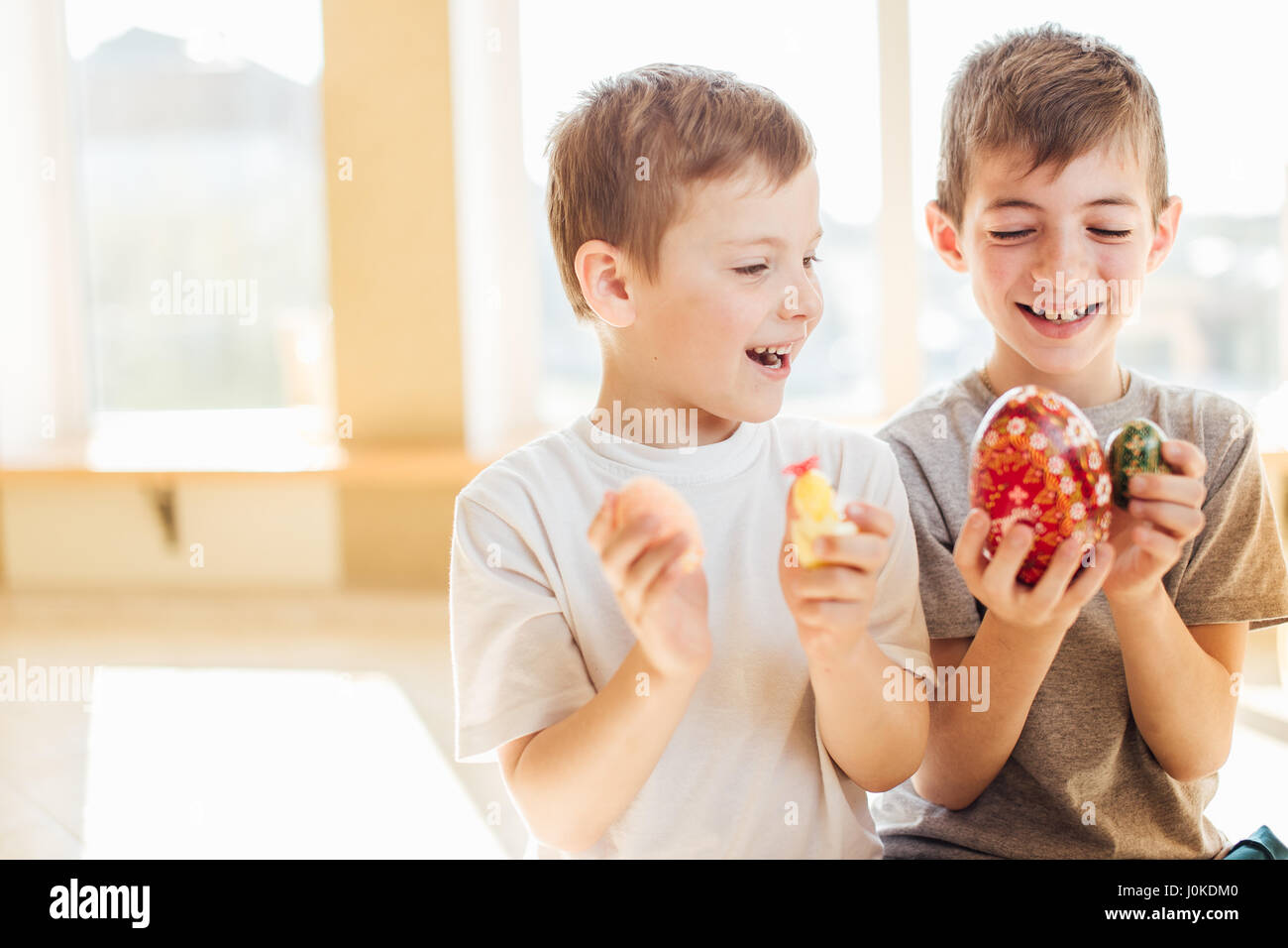 Due ragazzi tenendo le uova di Pasqua e il sorriso a ciascun altro Foto Stock