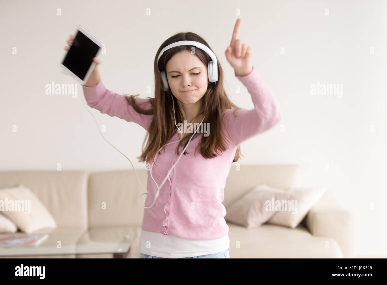 Teenage ragazza felici ascoltando la musica nelle cuffie e ballo Foto Stock