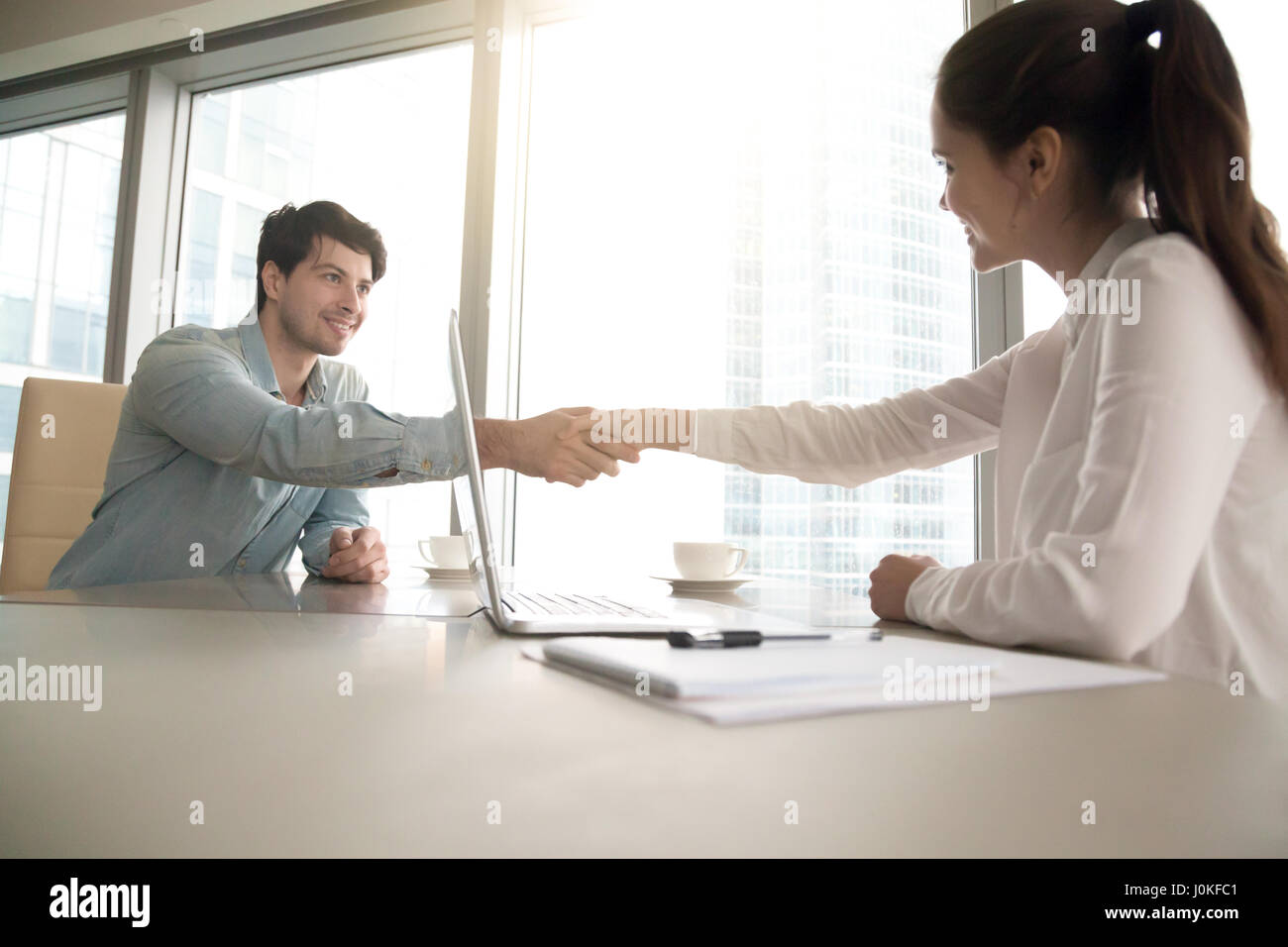 L uomo e la donna lo handshaking a office, business meeting, processo inte Foto Stock