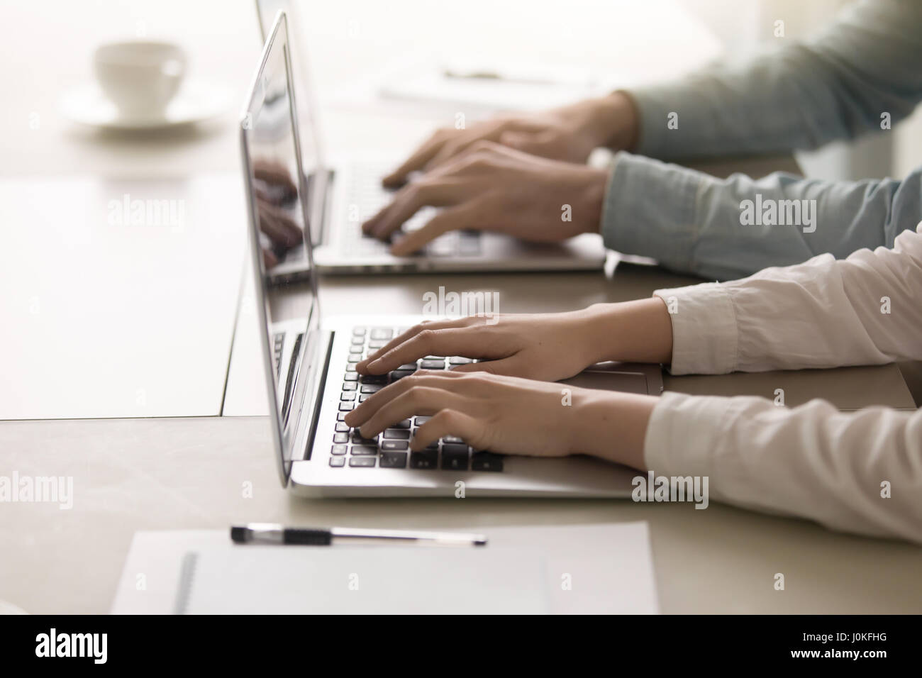 Maschio e femmina le mani sulla tastiera, lavorando su laptop, primo piano Foto Stock