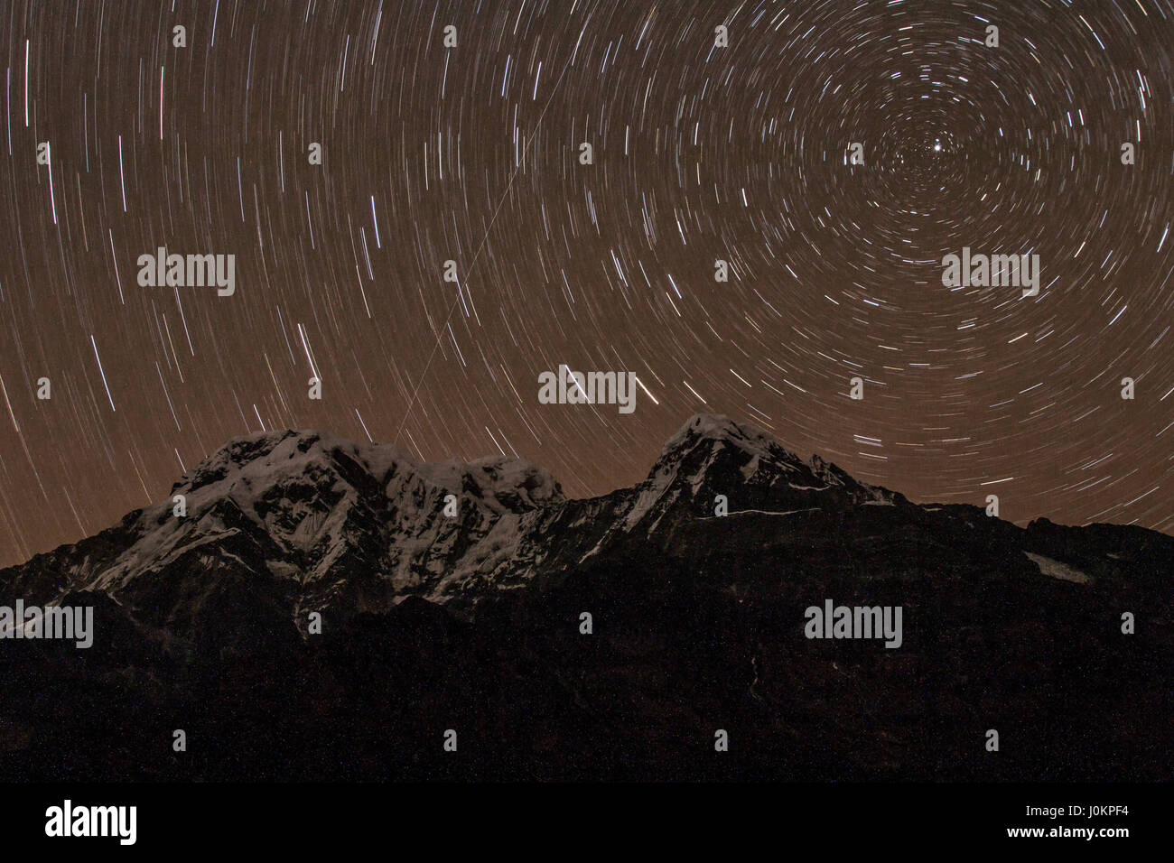 Le stelle al di sopra di Annapurna sud durante una notte di un trek attraverso l'Himalaya Foto Stock