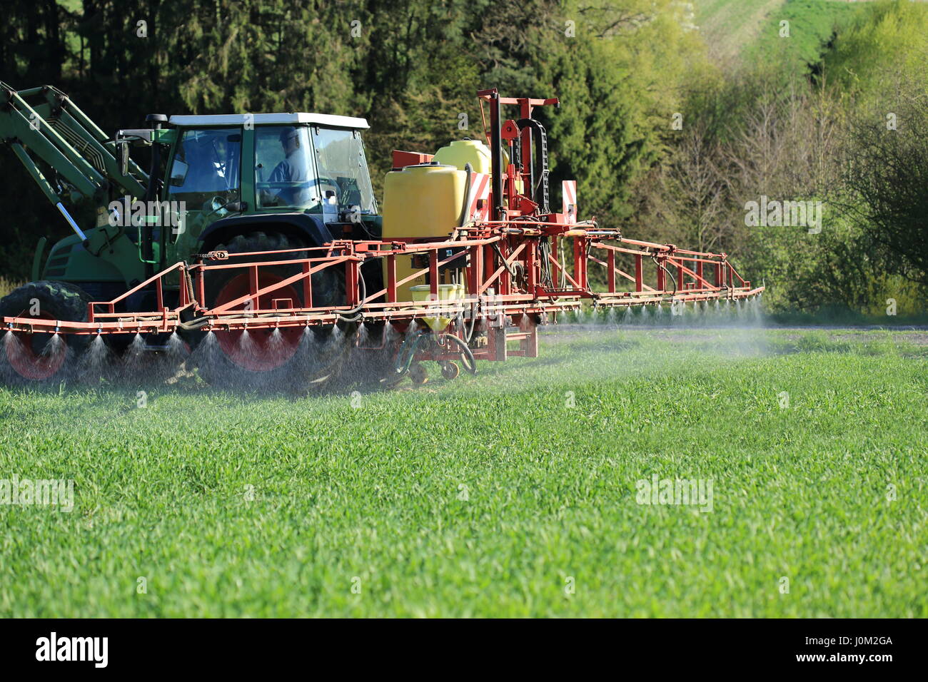 Un trattore la spruzzatura di pesticidi agricoltura Foto Stock