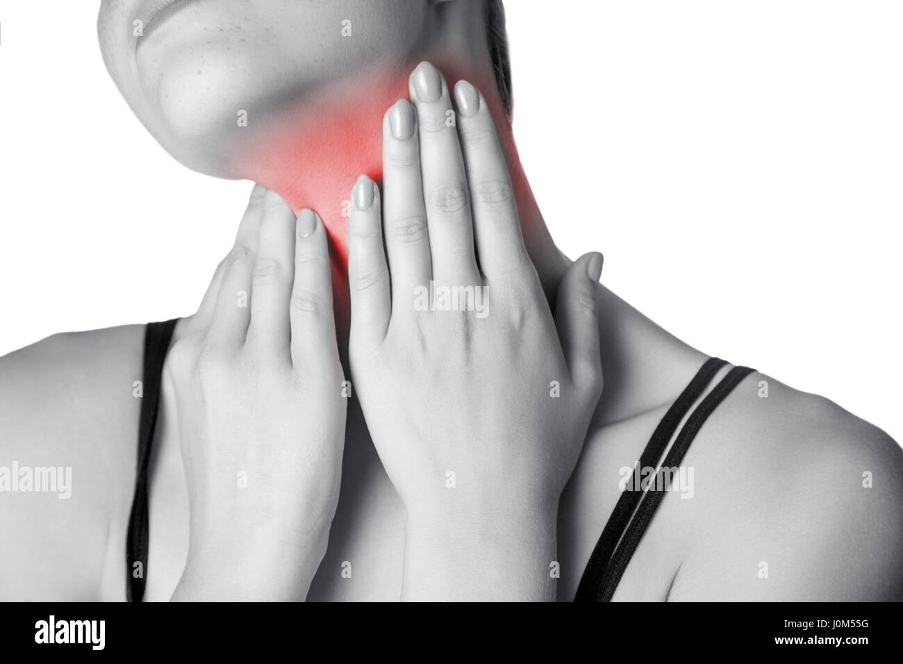 Primo piano di una giovane donna con dolore al collo o ghiandola tiroide isolato su sfondo bianco. Foto in bianco e nero con red dot. Foto Stock