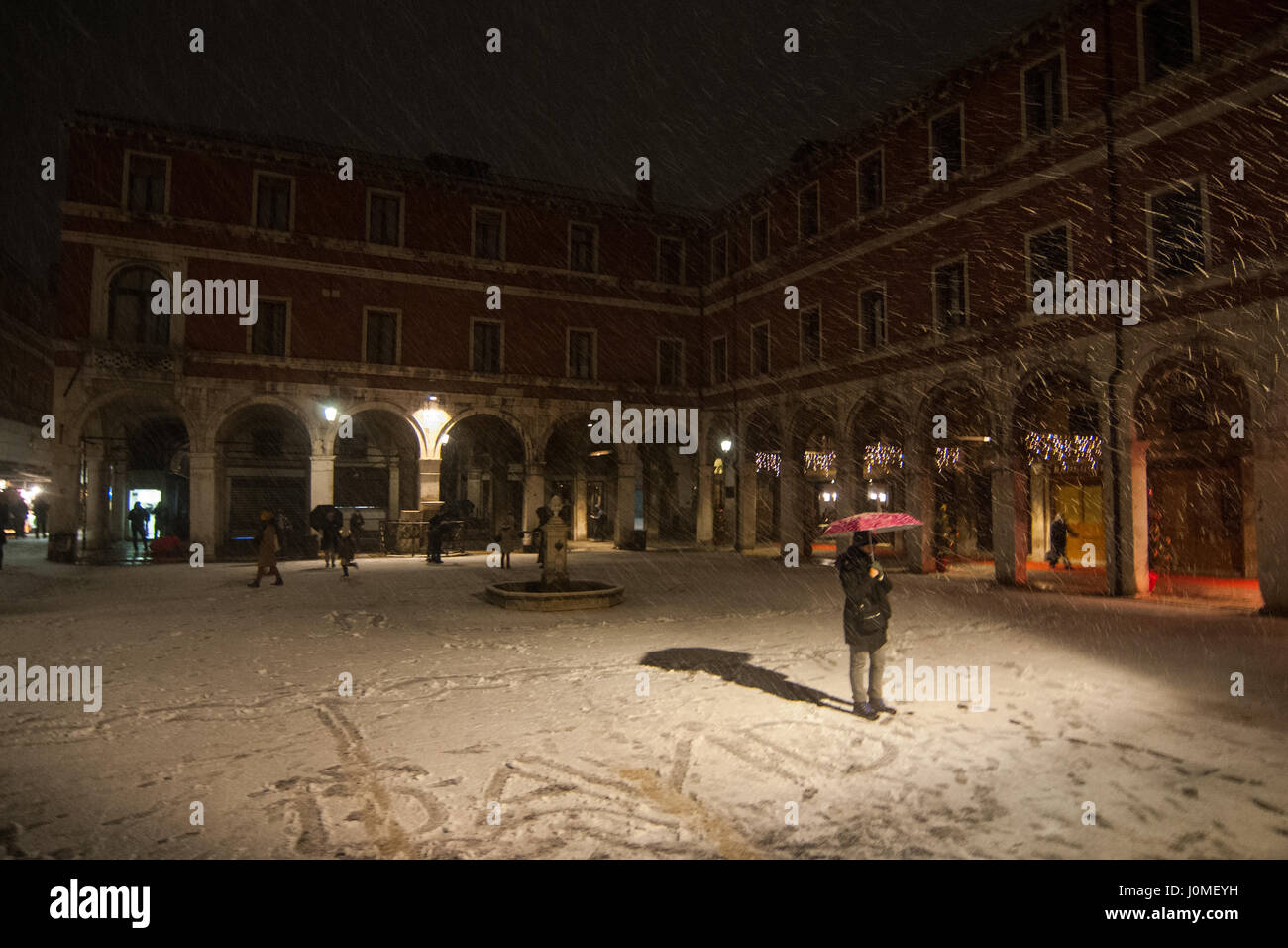 Una donna pone durante un pesante la caduta di neve a Venezia. Foto Stock