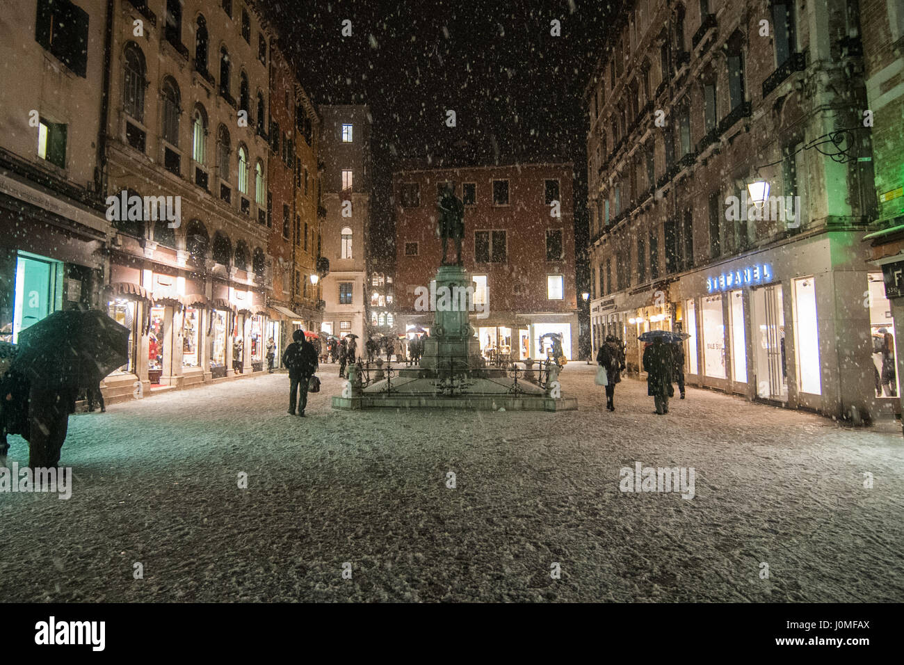 La gente a piedi a San Bartolomeo piazza durante una pesante caduta di neve a Venezia. Foto Stock
