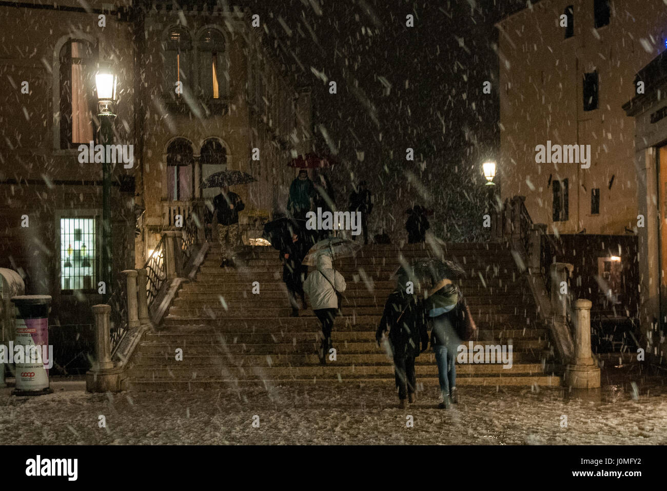 La gente a piedi in una strada durante un pesante la caduta di neve a Venezia. Foto Stock