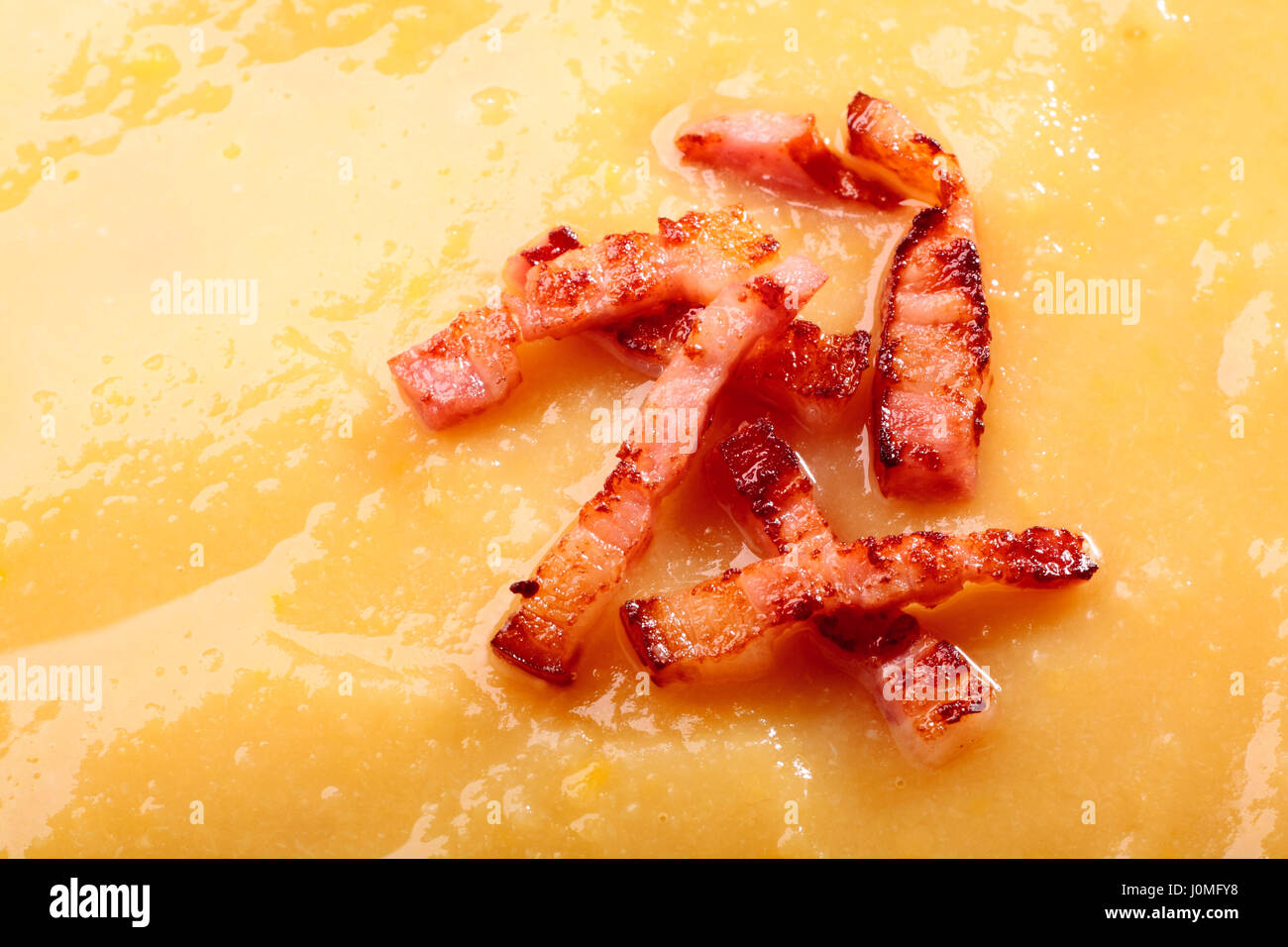 Close-up di crema di zuppa di piselli con pancetta fritta Foto Stock