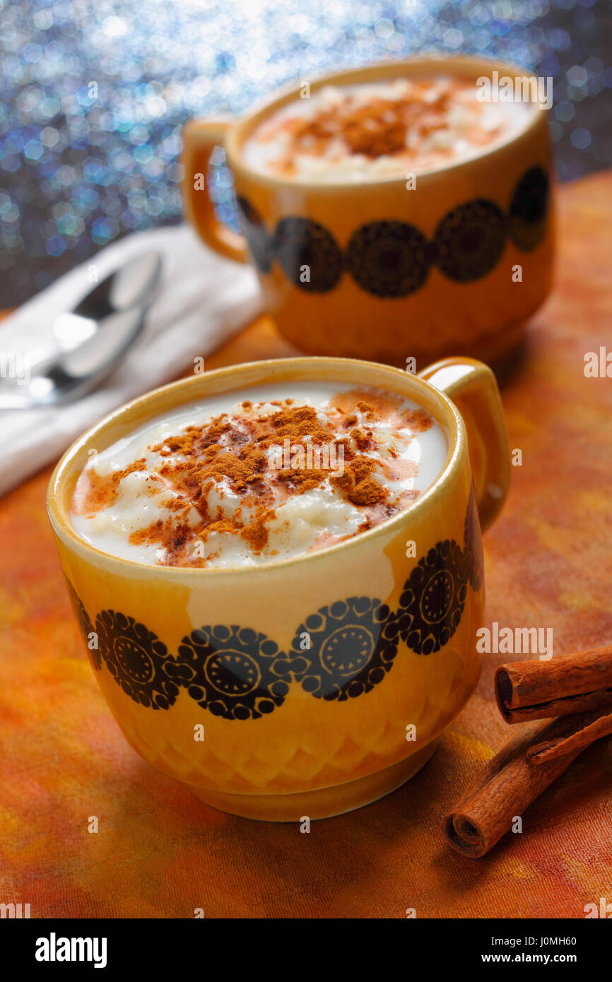 Due tazze riempite da budino di riso con cannella. Telaio obliquo, concentrarsi sulla prima coppa. Foto Stock