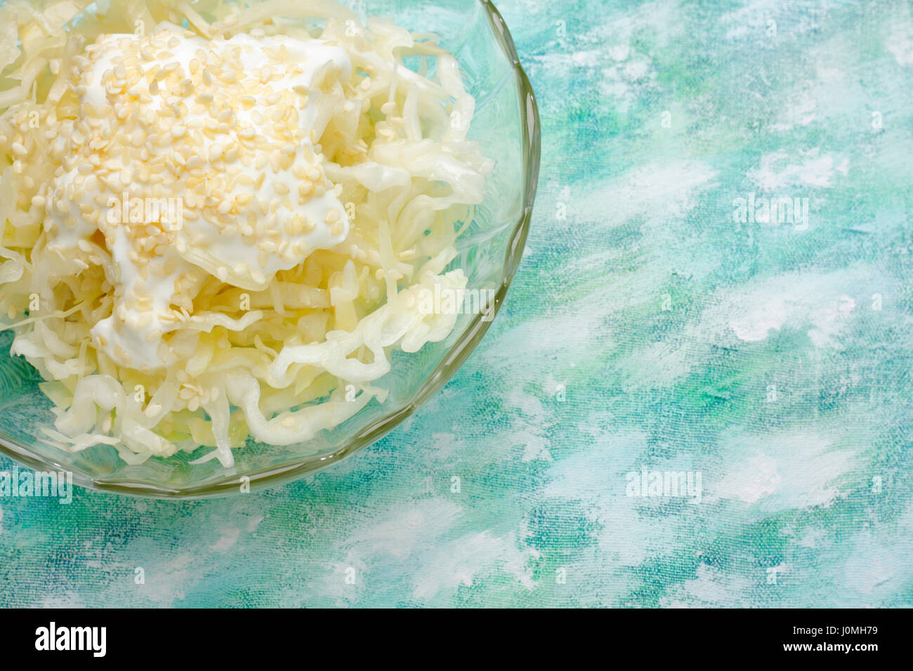 Bianco insalata di cavolo con panna e topping di sesamo in coppa sopra dipinta sullo sfondo tessili. Vista aerea con copia spazio. Foto Stock