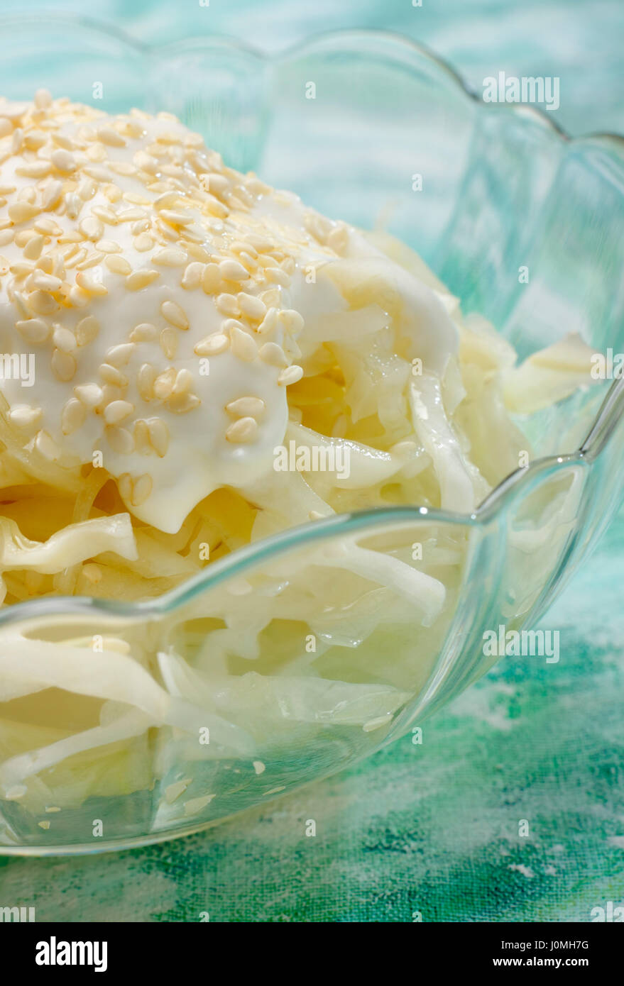 Dettaglio di bianco insalata di cavolo con panna e topping di sesamo in recipiente di vetro Foto Stock