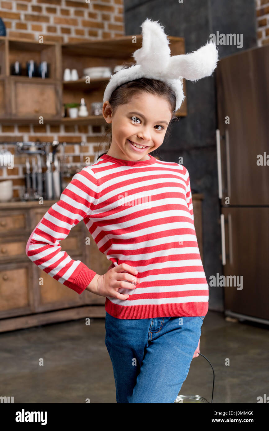 Adorabile bambina in bianco orecchie di coniglietto sorridente in telecamera Foto Stock