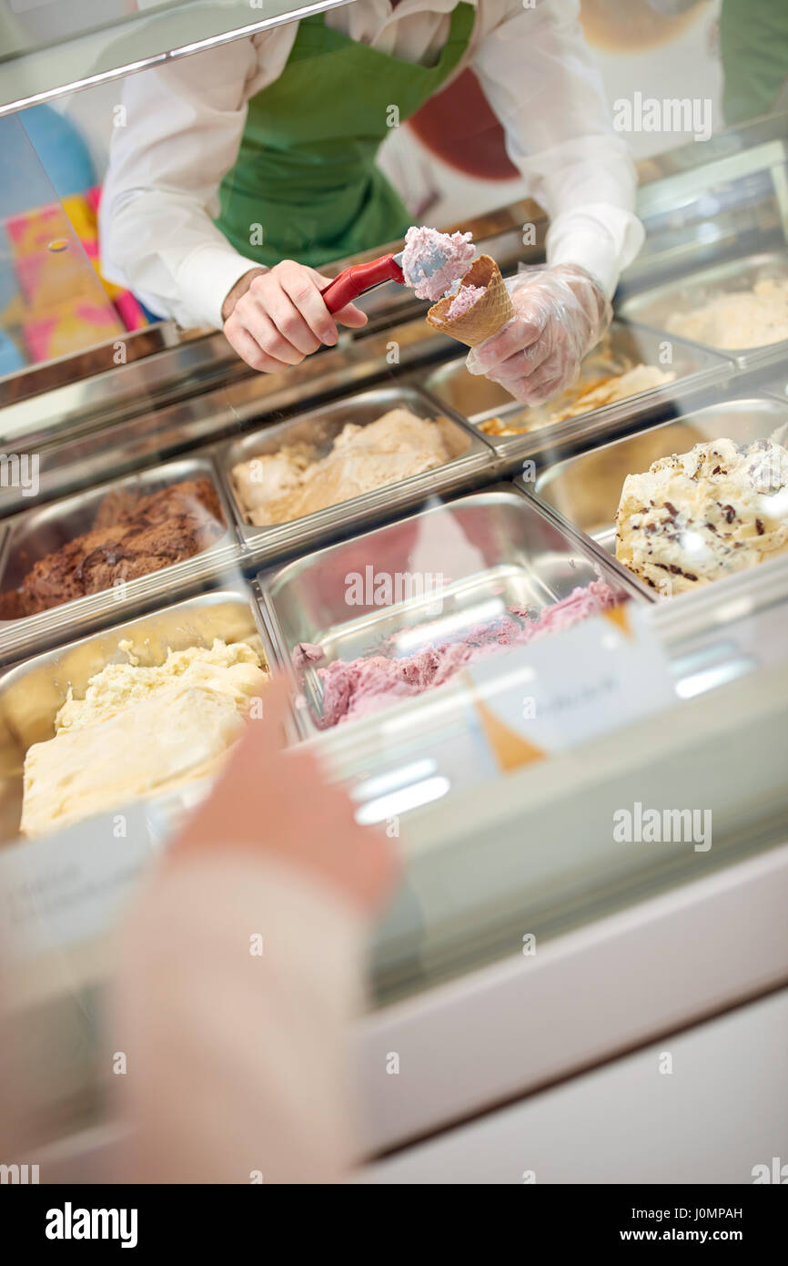 Riempimento con coni gelato dal caso di vetro in pasticceria Foto Stock
