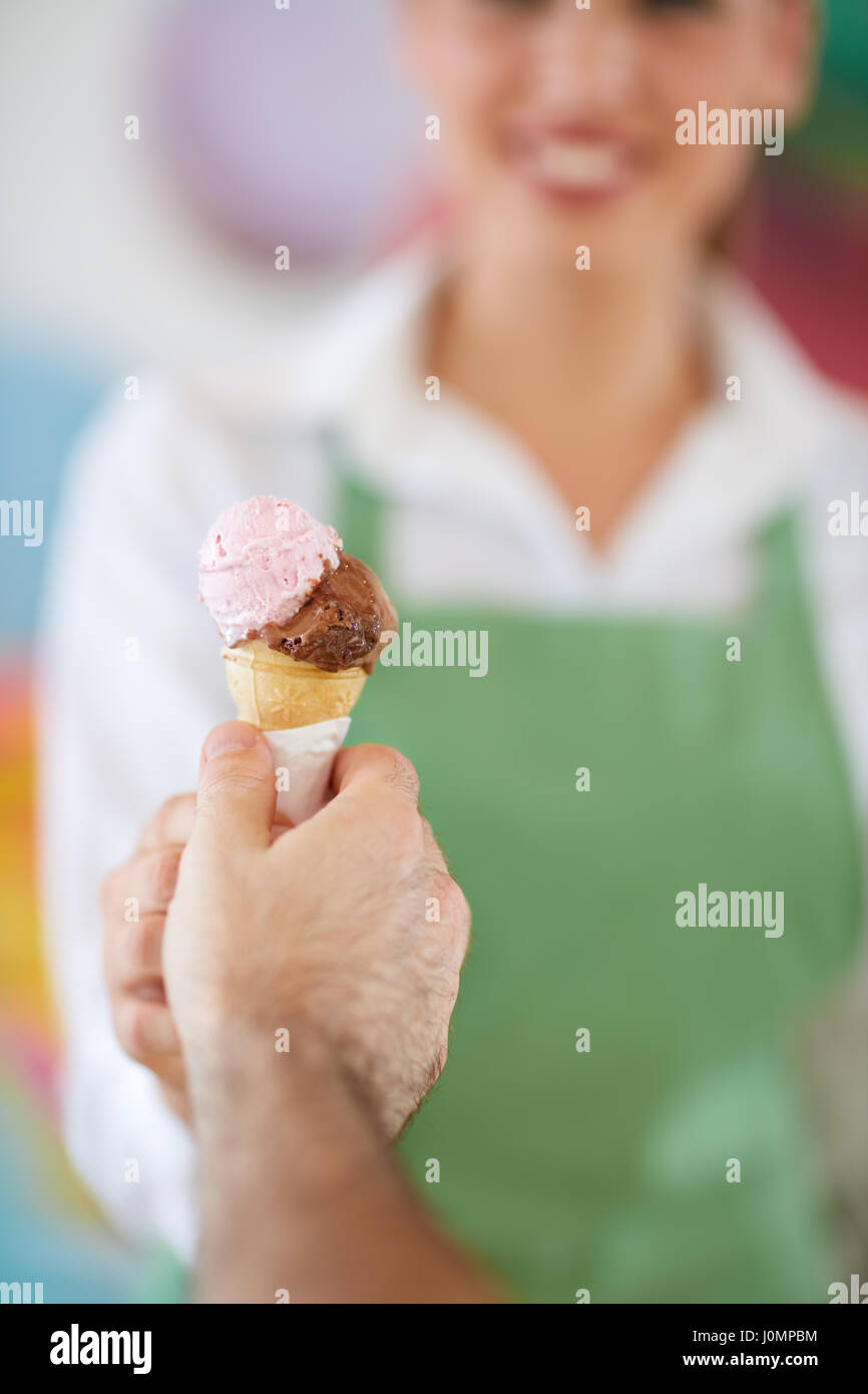 Stretta di mano del cliente prendendo il gelato in una pasticceria Foto Stock