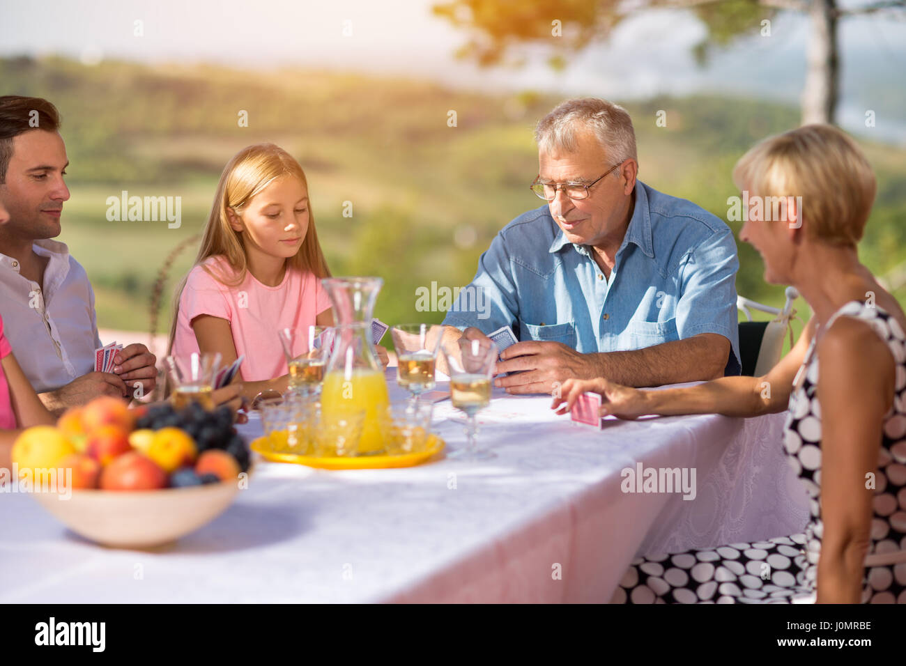 Tempo libero - famiglia giocando a carte in giardino Foto Stock