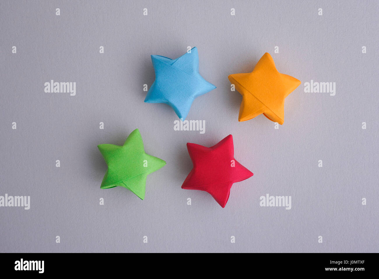 Origami colorati lucky stelle sulla carta grigia sullo sfondo. Foto Stock