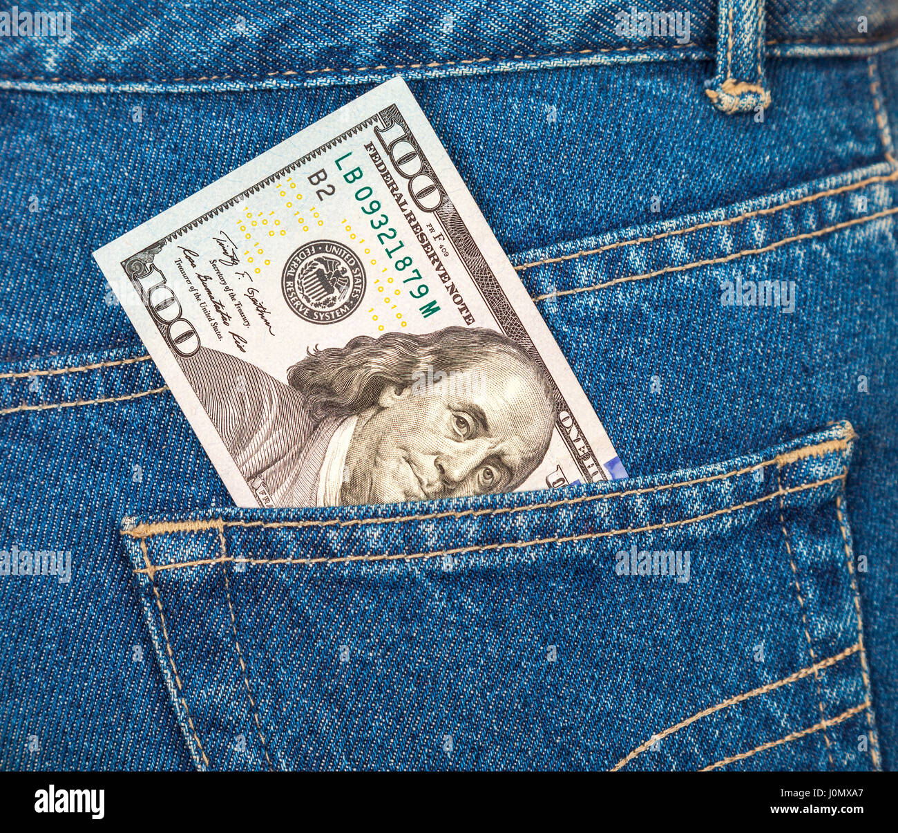 La banconota di cento dollari americani fuori del blue jeans pocket Foto Stock