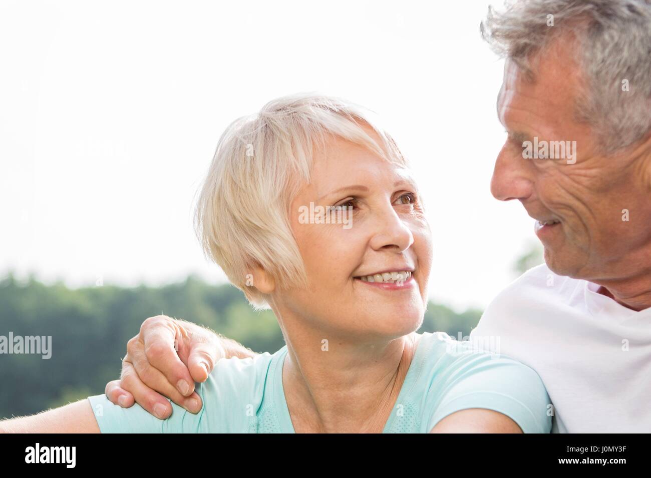 Coppia senior sorridente, uomo con braccio attorno alla donna. Foto Stock