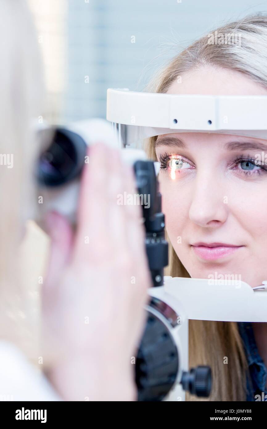 Paziente di sesso femminile avente occhio in esame all'ottico optometrista del negozio, close-up. Foto Stock