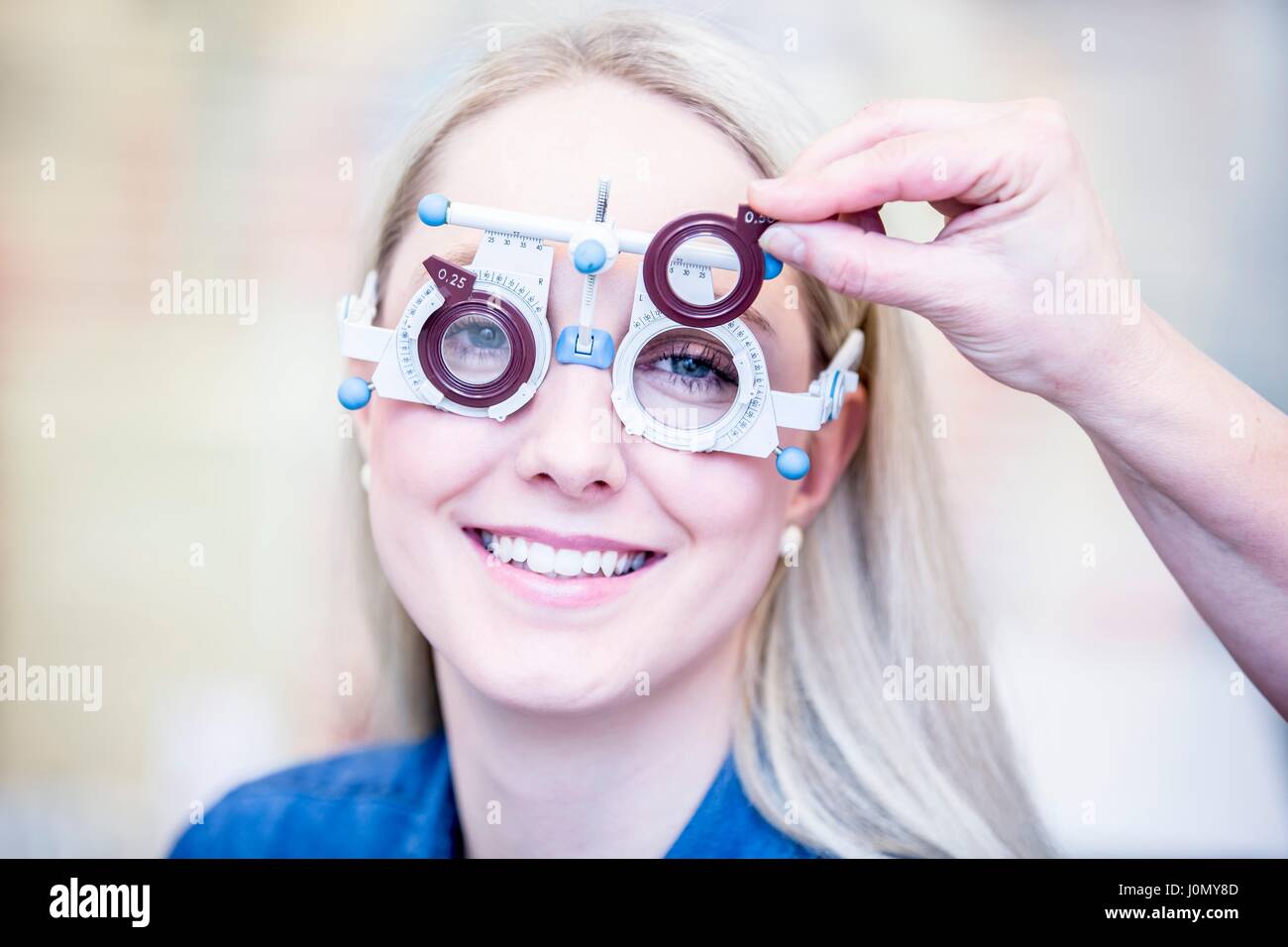 Ritratto di Allegro giovane donna con occhio in esame all'ottico optometrista del negozio, close-up. Foto Stock