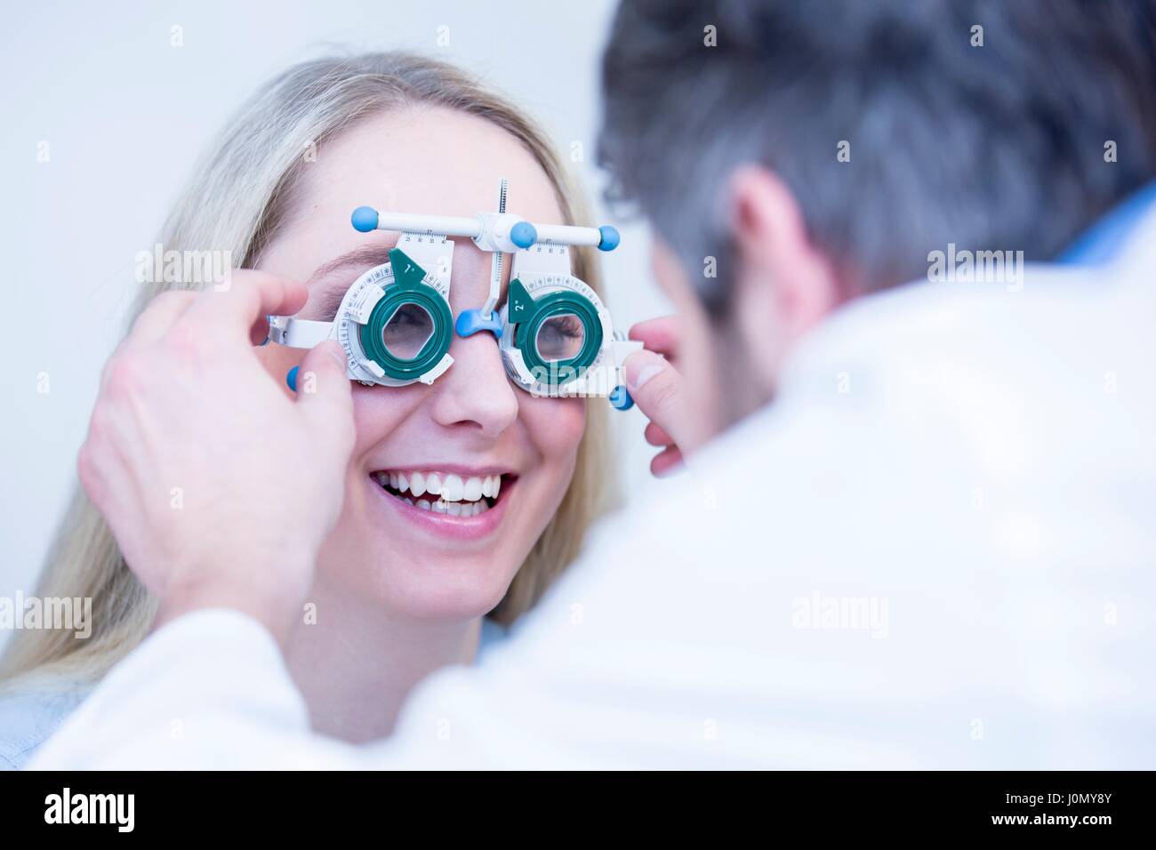 All'ottico optometrista eseguendo la prova degli occhi di giovane donna. Foto Stock