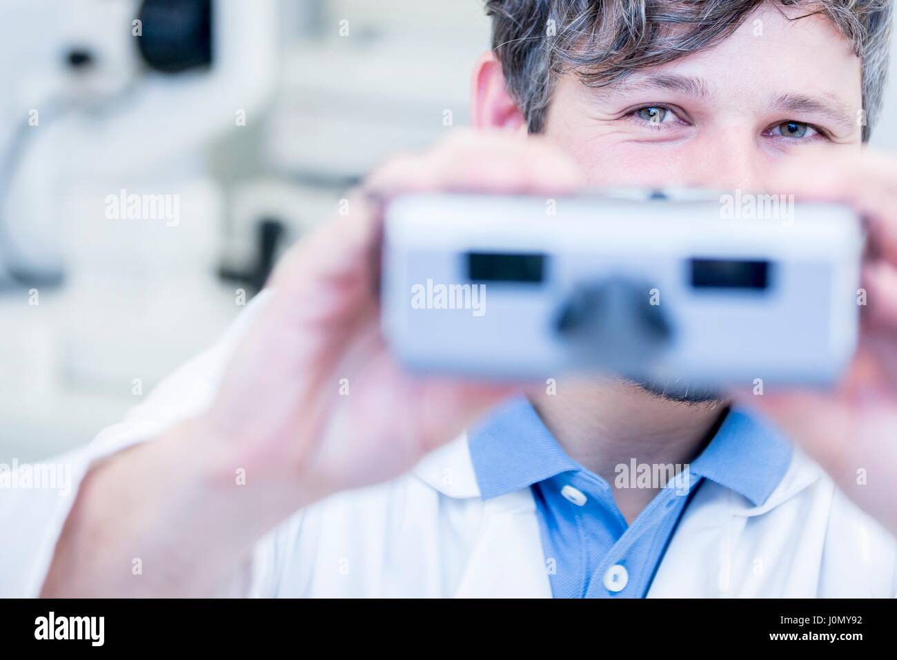 Ritratto di all'ottico optometrista eseguendo la prova dell'occhio con visione screener in all'ottico optometrista del negozio. Foto Stock