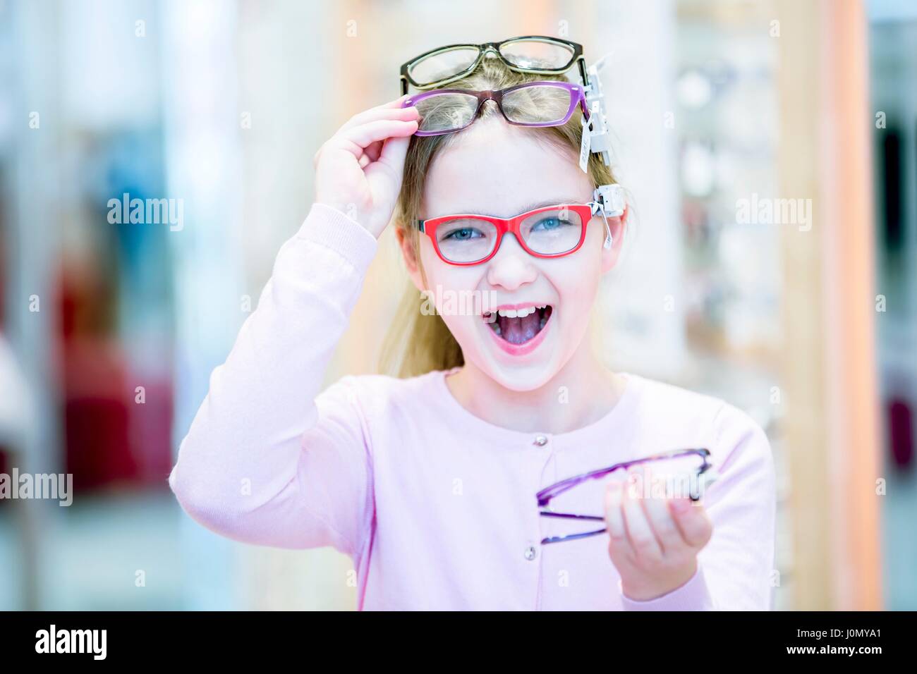 Ritratto di ragazza cercando bicchieri in all'ottico optometrista del negozio. Foto Stock