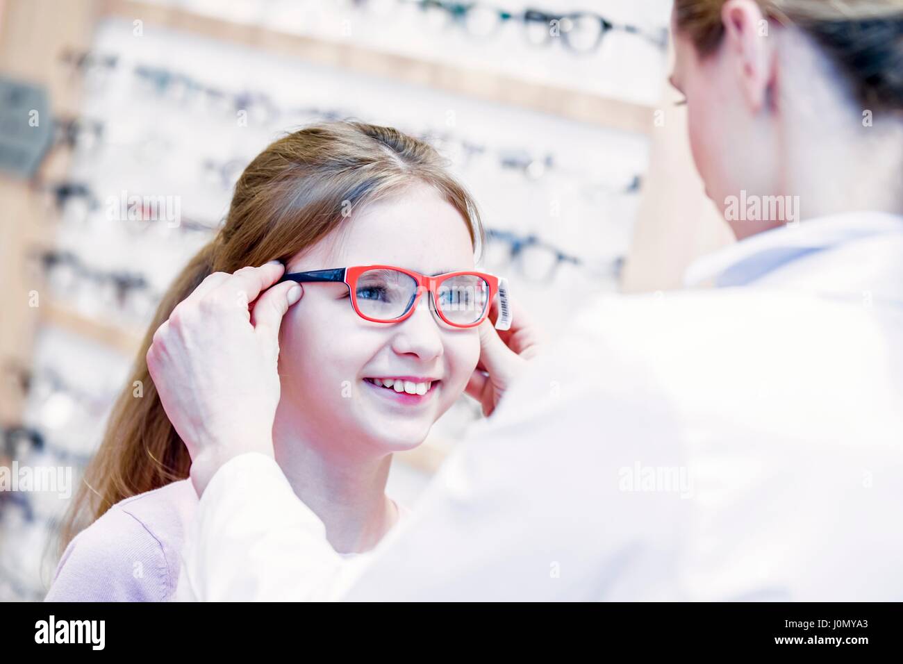 All'ottico optometrista cercando gli occhiali sulla ragazza in all'ottico optometrista del negozio. Foto Stock