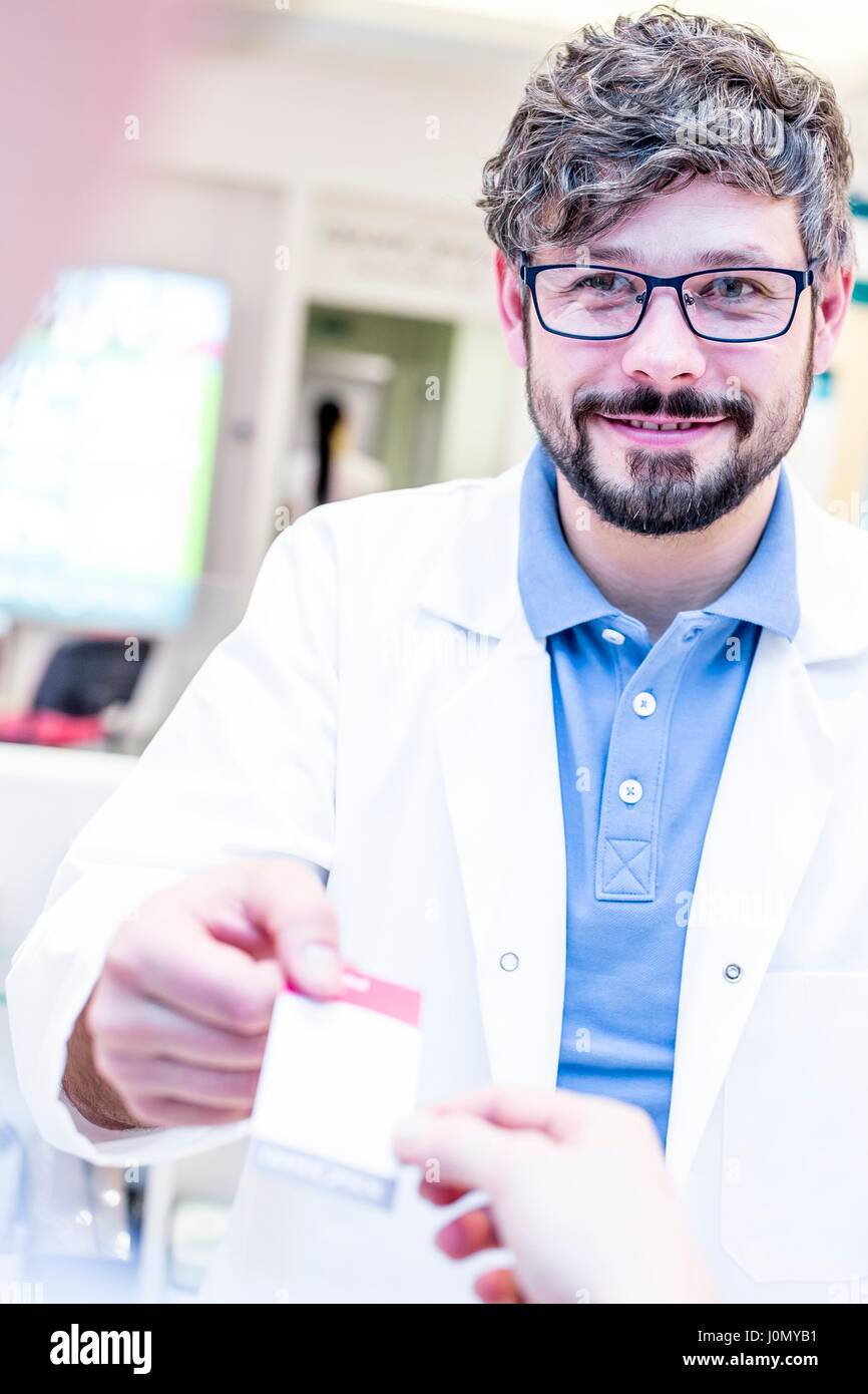 All'ottico optometrista consegna ricevuta alla donna. Foto Stock