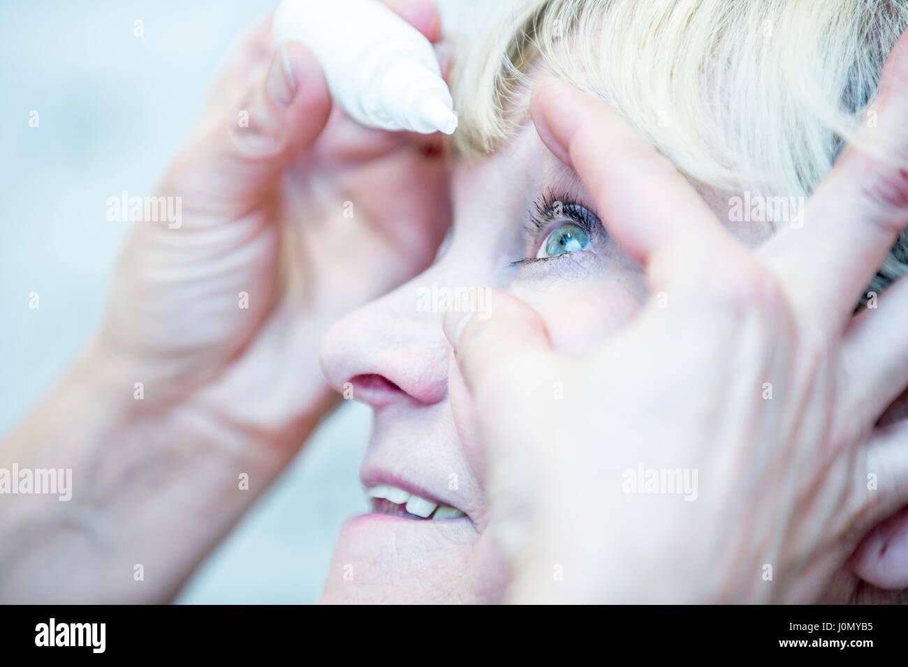 Close-up della persona che chieda di gocce per gli occhi. Foto Stock