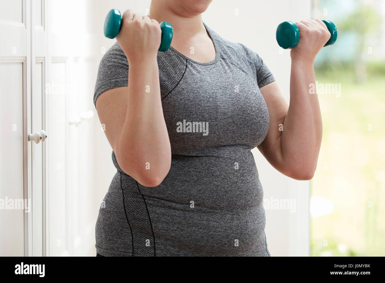 Donna che utilizza i pesi a mano. Foto Stock