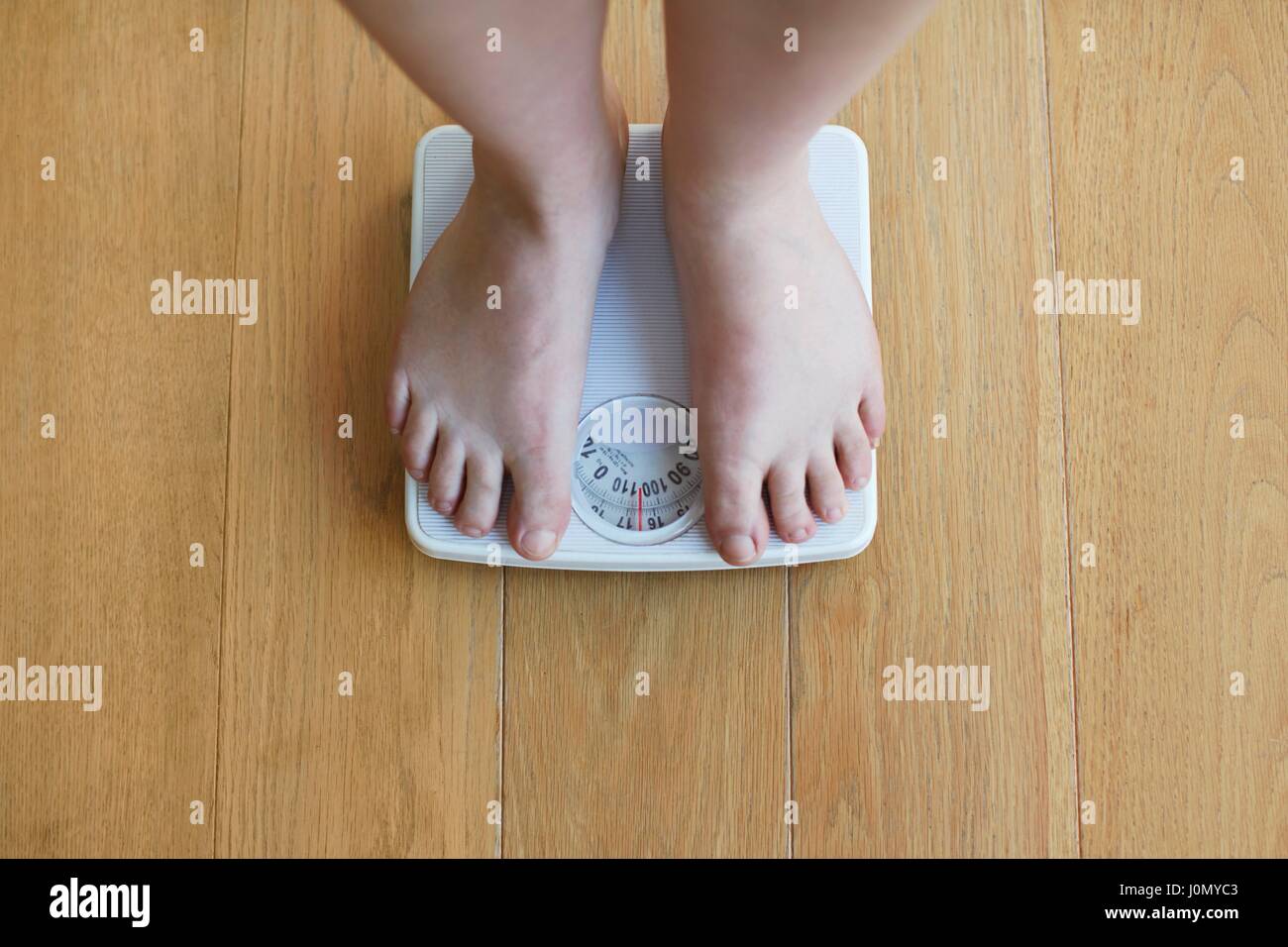 Donna in piedi su una bilancia. Foto Stock