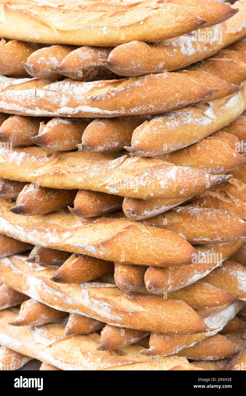 Francese impilati freschi di forno pani baguette di pane tra i prodotti alimentari in vendita al mercato di strada Bordeaux, Francia Foto Stock