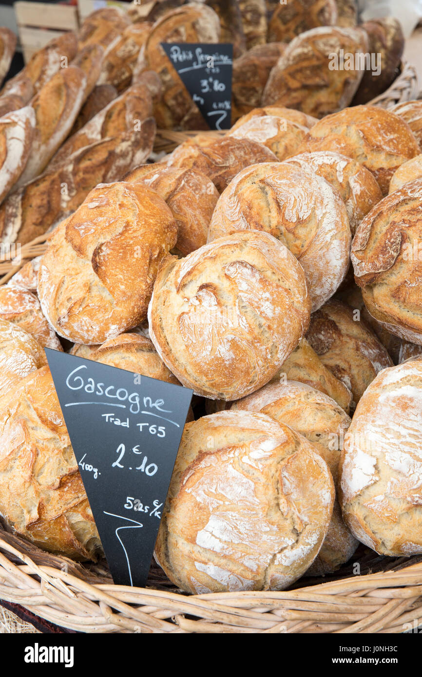 Il francese sfornato fresco Guascogna il pane nel cesto di vimini tra i prodotti alimentari in vendita al mercato di strada bordeaux, Francia Foto Stock