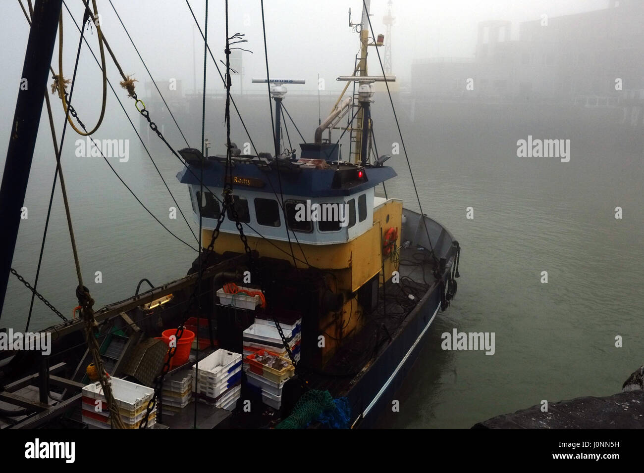 La pesca in barca nel porto su un nebbioso giorno a Oostende Foto Stock