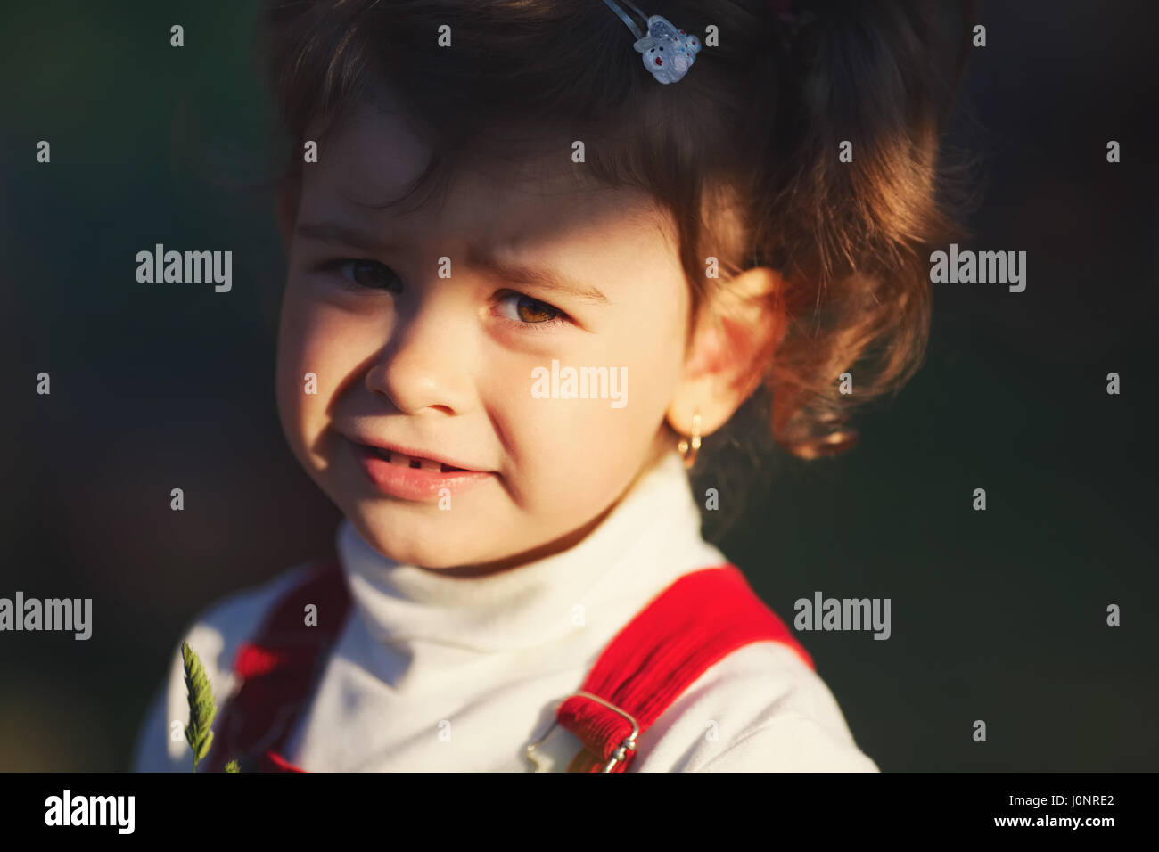 Bambina con raggi del sole sulla faccia Foto Stock