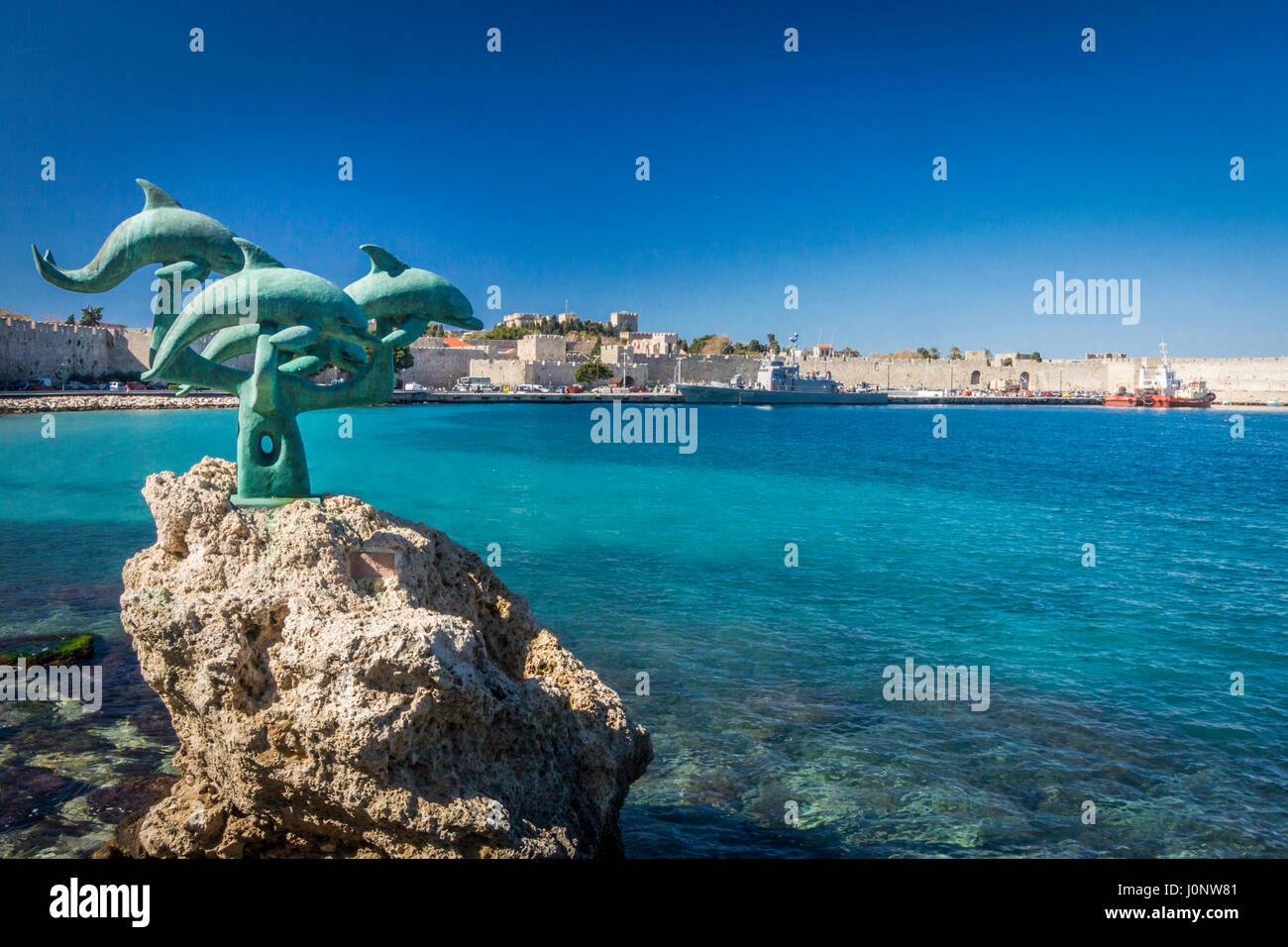 In bronzo della scultura di delfini al porto della città antica di Rodi, Grecia Foto Stock