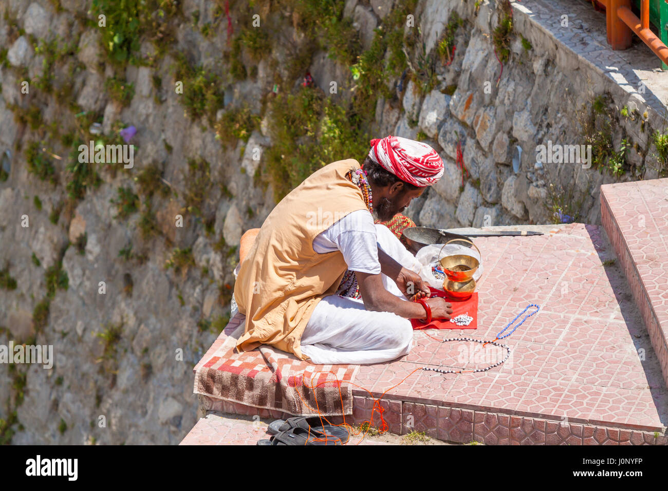 BADRINATH - INDIA, 5 giugno - Un sadhu vende perline di santo sui gradini nei pressi del tempio di Badarinath in India del Nord il 5 giugno 2013 Foto Stock